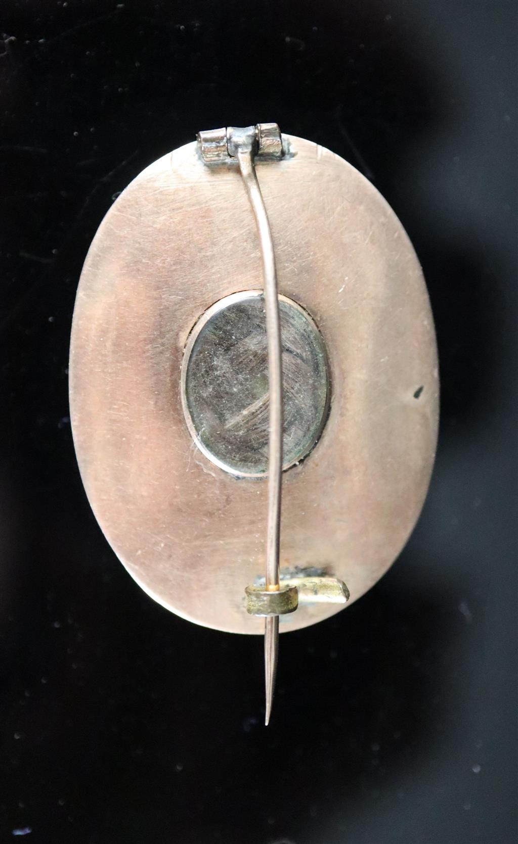 A Georgian gold mounted oval mourning brooch, with painted panel depicting an eye,